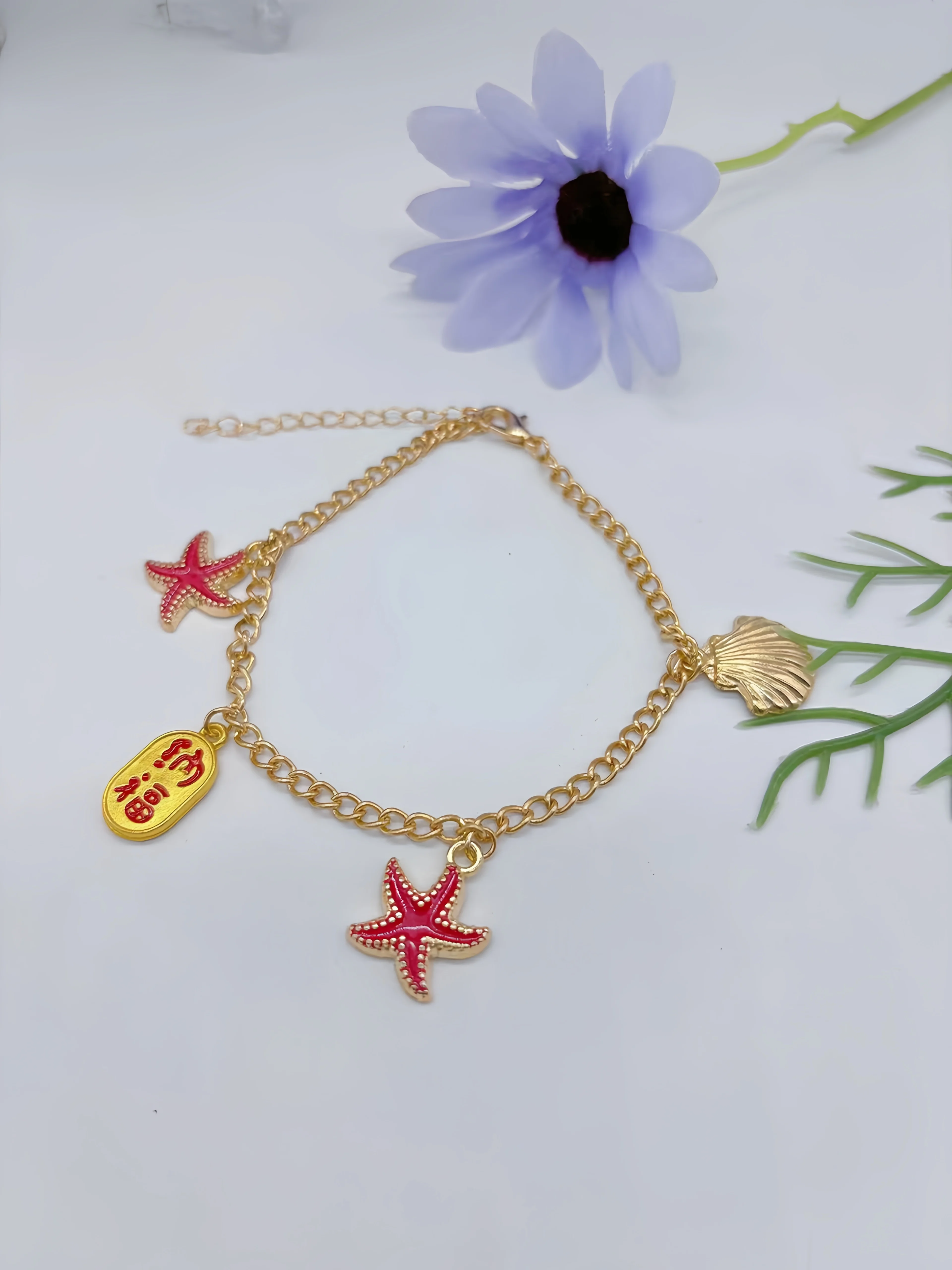 Bransoletka na kostkę, z różnymi charmsami, błyszczącymi ozdobami,