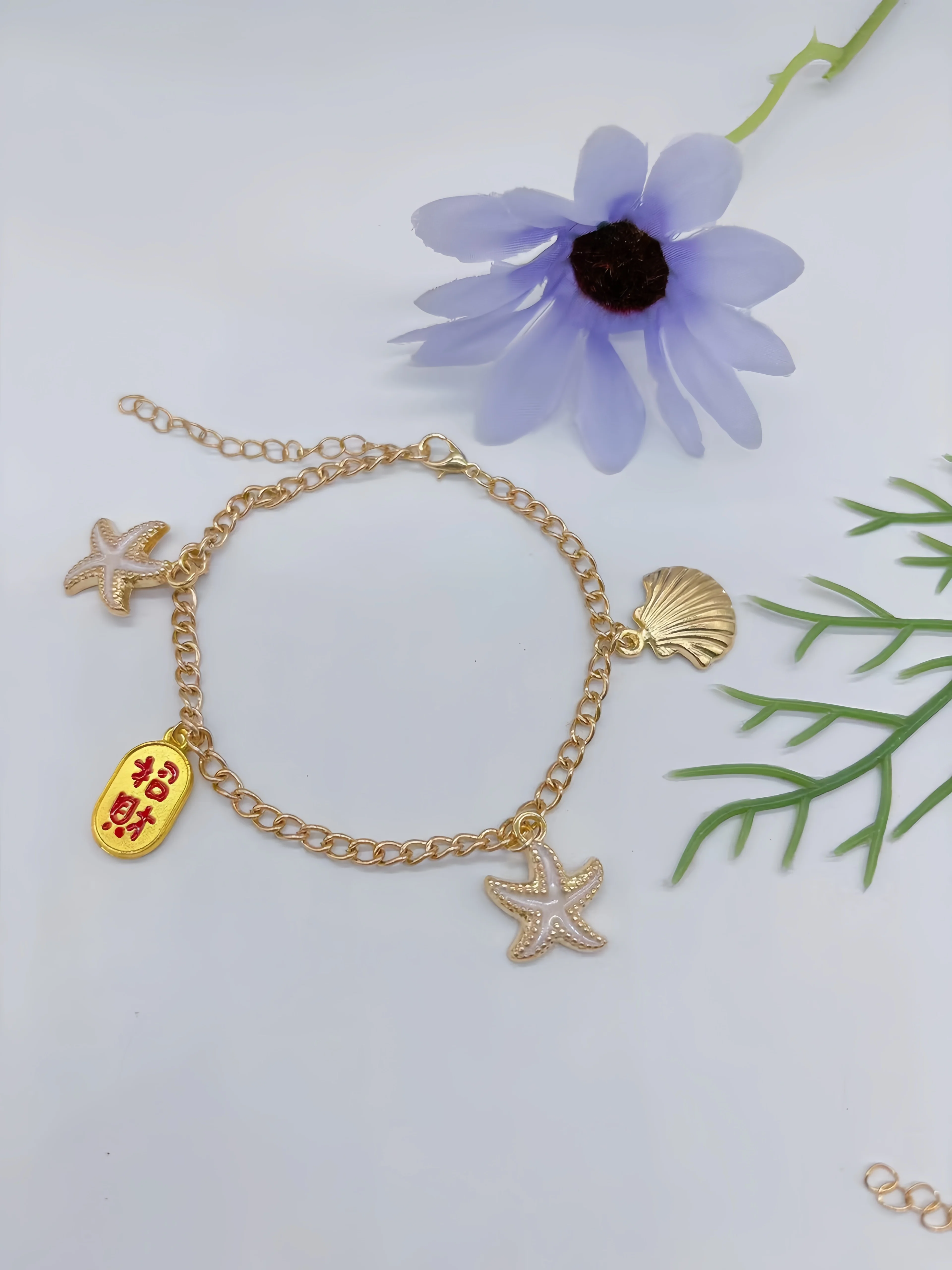 Bransoletka na kostkę, z różnymi charmsami, błyszczącymi ozdobami,