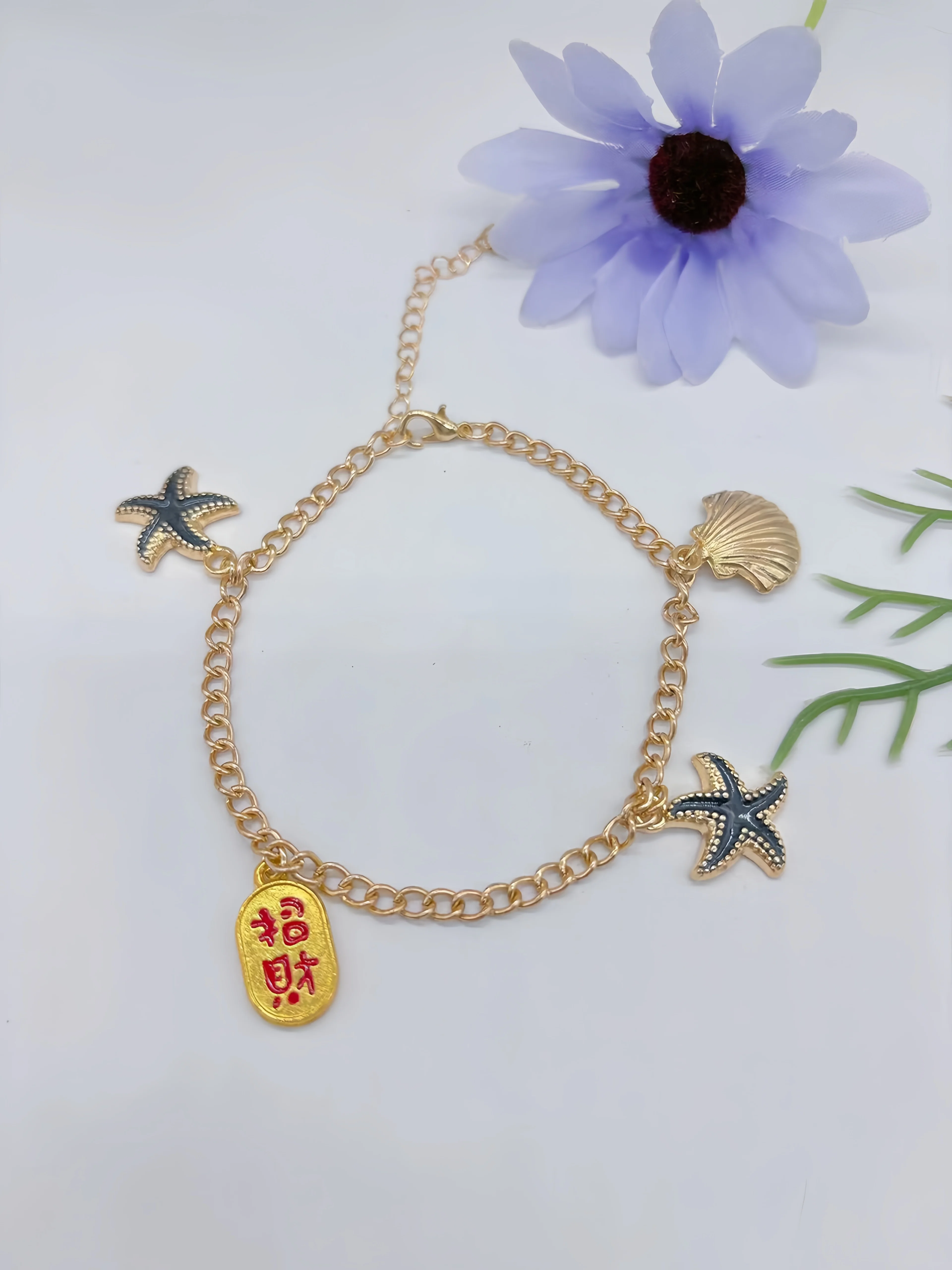 Bransoletka na kostkę, z różnymi charmsami, błyszczącymi ozdobami,