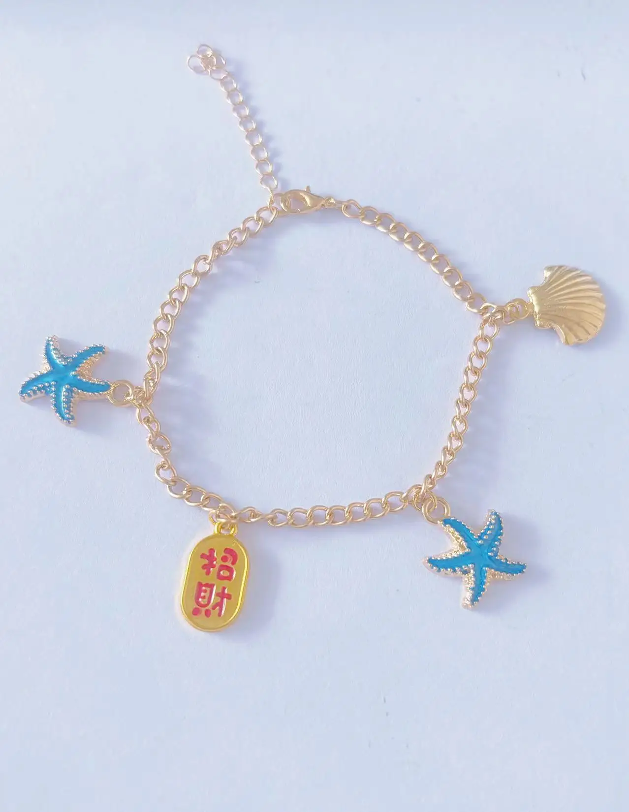 Bransoletka na kostkę, z różnymi charmsami, błyszczącymi ozdobami,